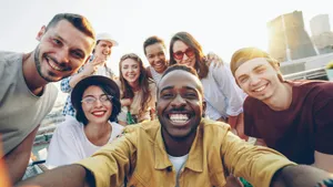 Diverse group of friends smiling together for a selfie outdoors