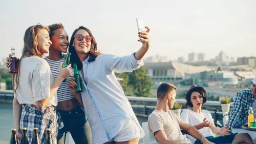 Friends taking a selfie together at a rooftop party