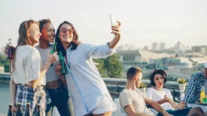 Friends taking a selfie together at a rooftop party